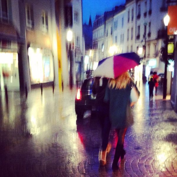Marcher sous la pluie avec une amie sous un parapluie
