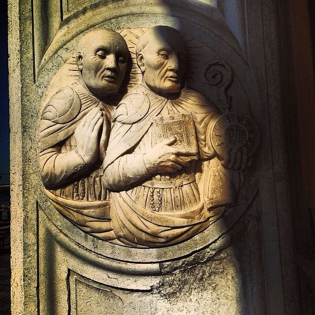 14. Sculpture d'un prête et d'un croyant dans l'embrasure d'une porte à Venise