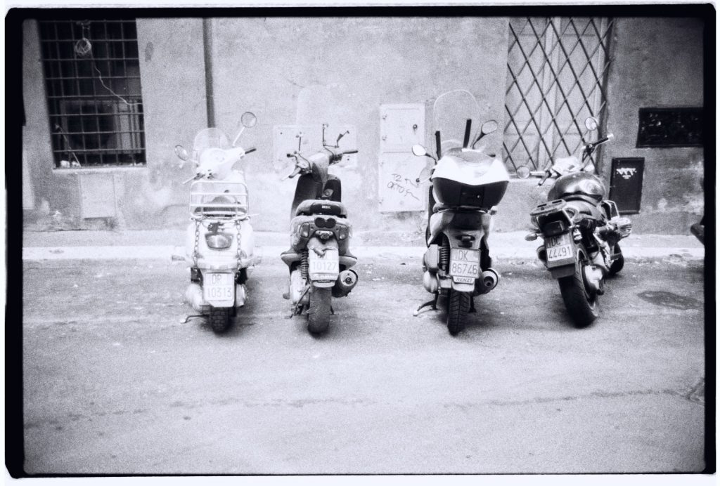 Des scooters stationnés dans une petite rue de Rome