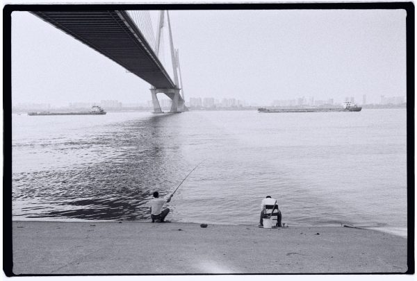 Des pêcheurs à l'ombre d'un pont sur les rives du Yangzi Jiang