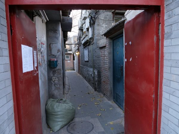 Une porte rouge marquant l'entrée dans un hutong à pékin