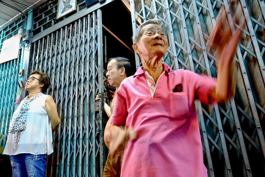 Des commerçants dans le quartier chinois de Bangkok regardant passer le carnaval pendant la fête du dragon