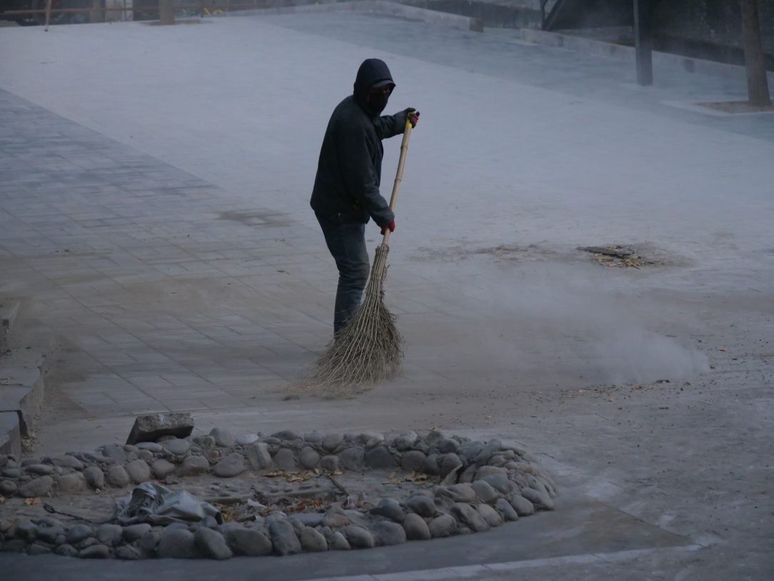 Un ouvrier nettoyant la rue après des travaux