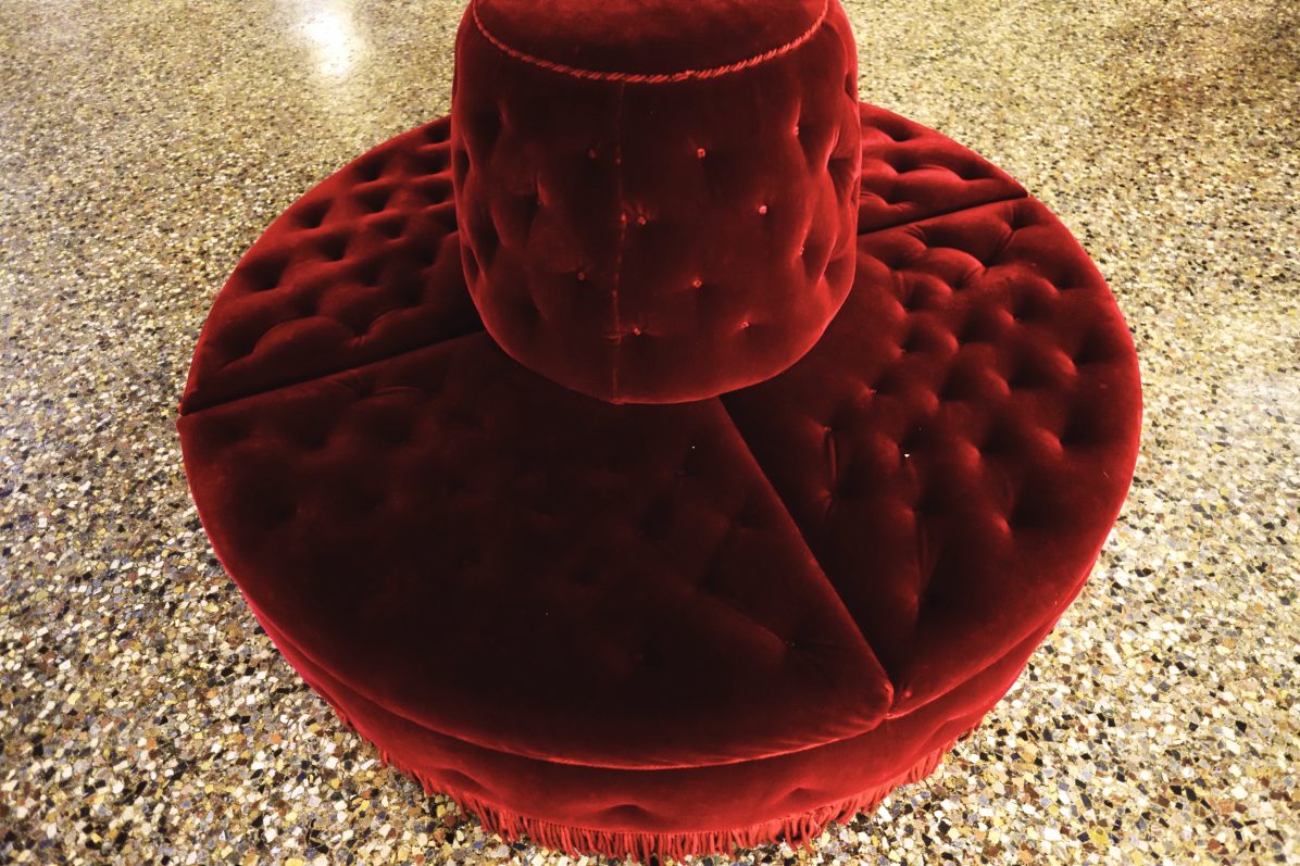 Un sofa rouge circulaire au niveau de l'amphithéâtre des quatrièmes loges
