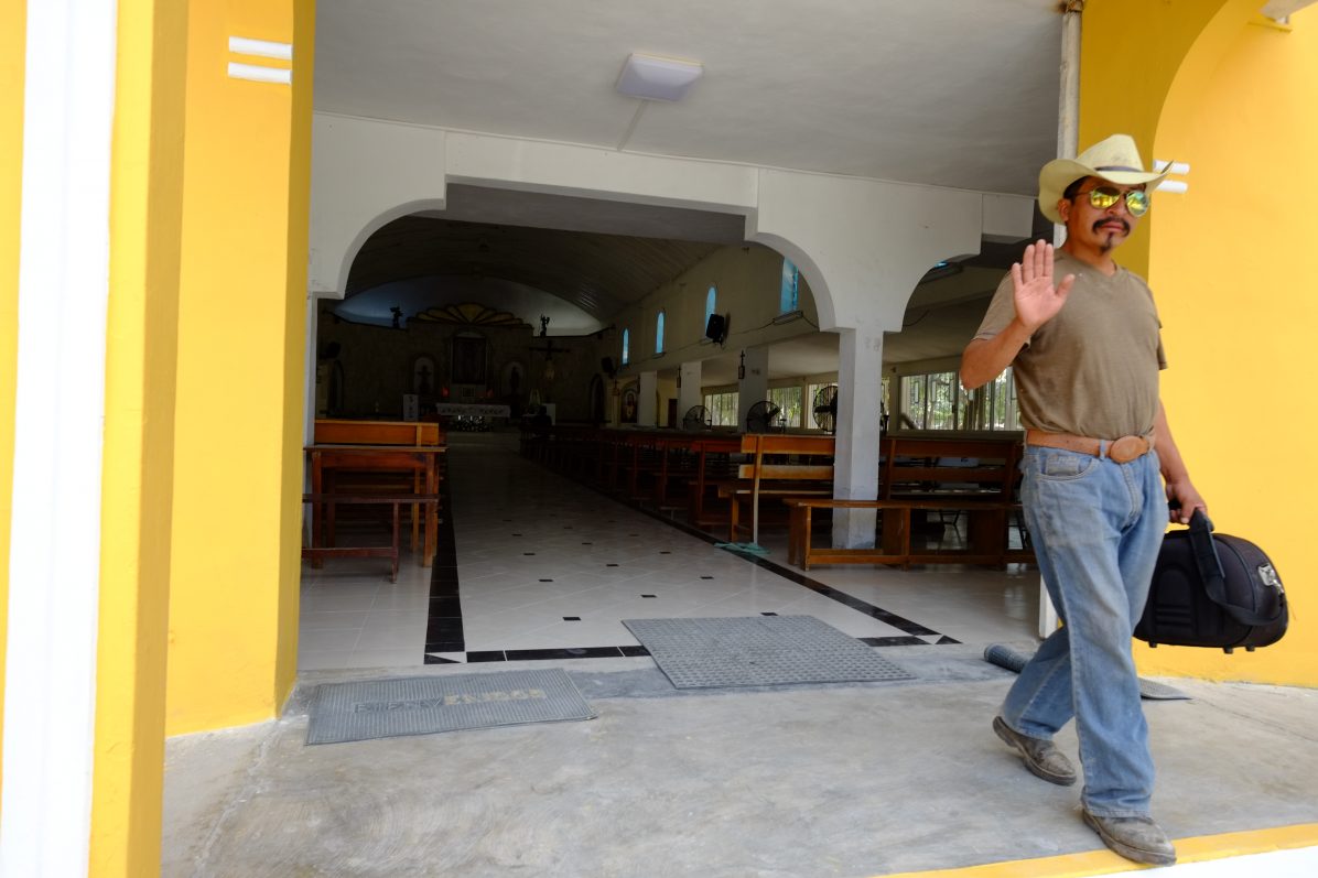 Un mexicain sortant d'une petite église colorée de Tulum