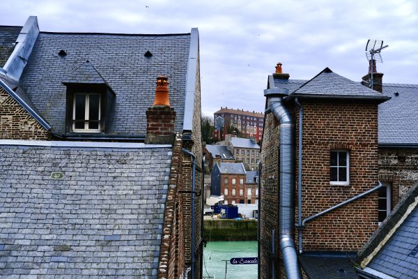 Une petite ruelle laissant apercevoir l'eau verte émeraude du port