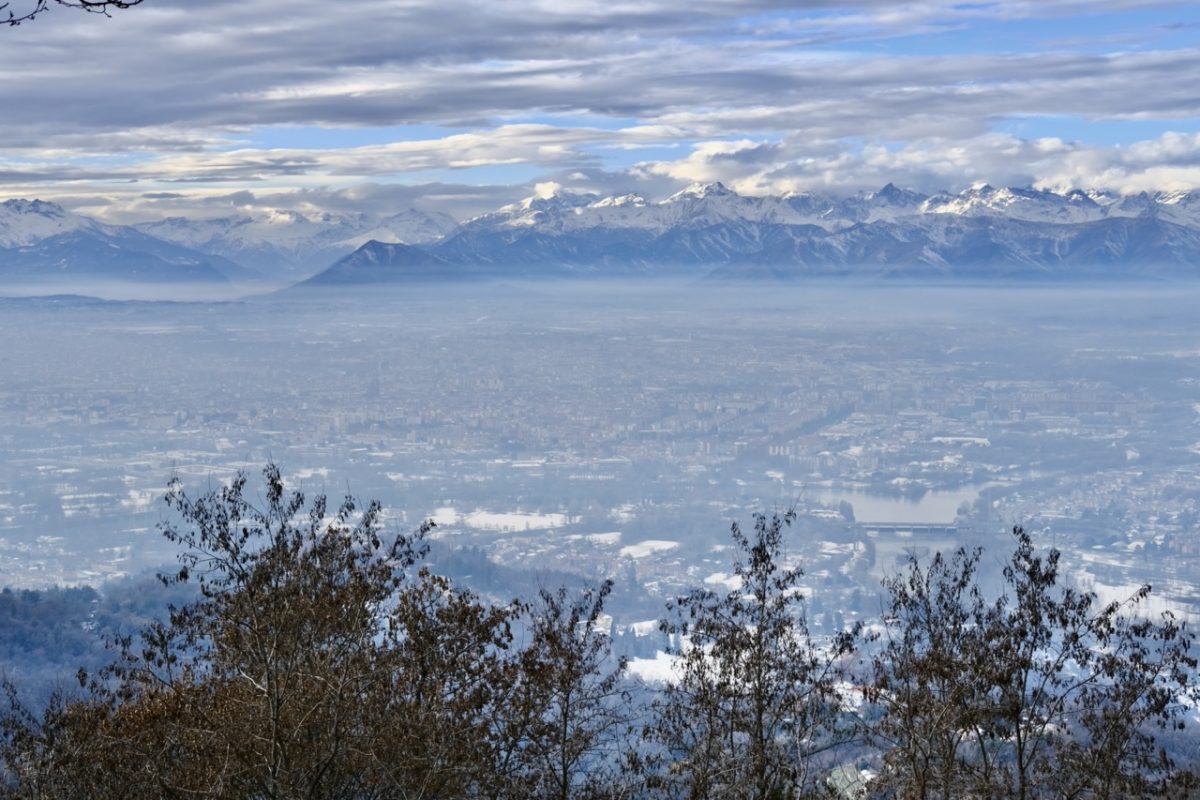 La ville de Turin dans la brume enserrée par les montagnes enneigées